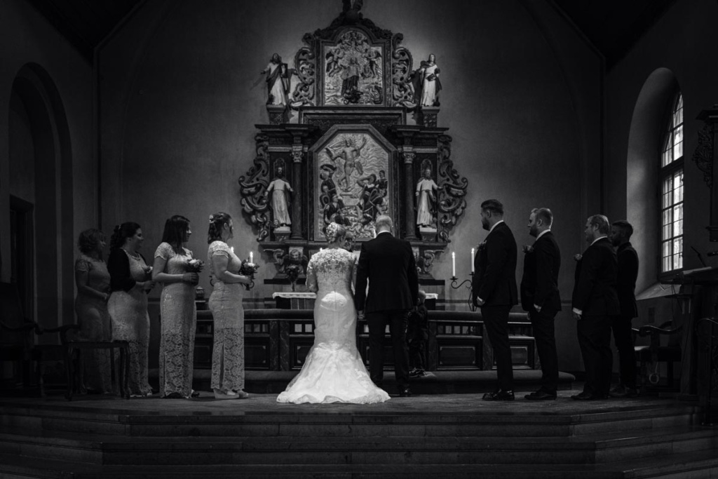 Bröllopspar står framför prästen vid altare