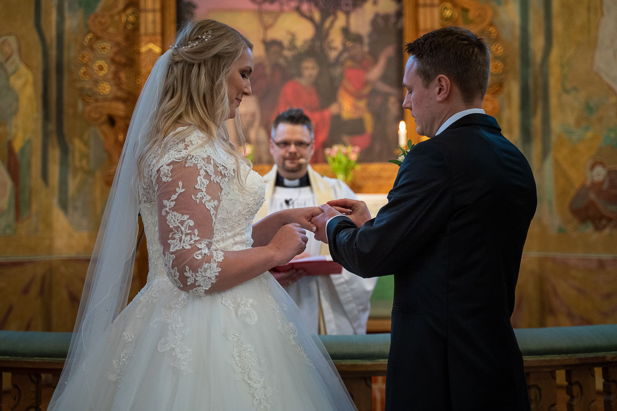 Brudgummen ger bruden vigselringen i Trefaldighetskyrkan i Arvika
