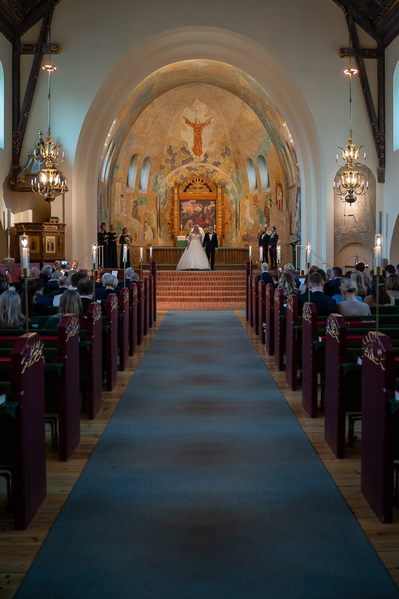 bild av altargång och altare samt bröllopspar i Trefaldighetskyrkan i Arvika