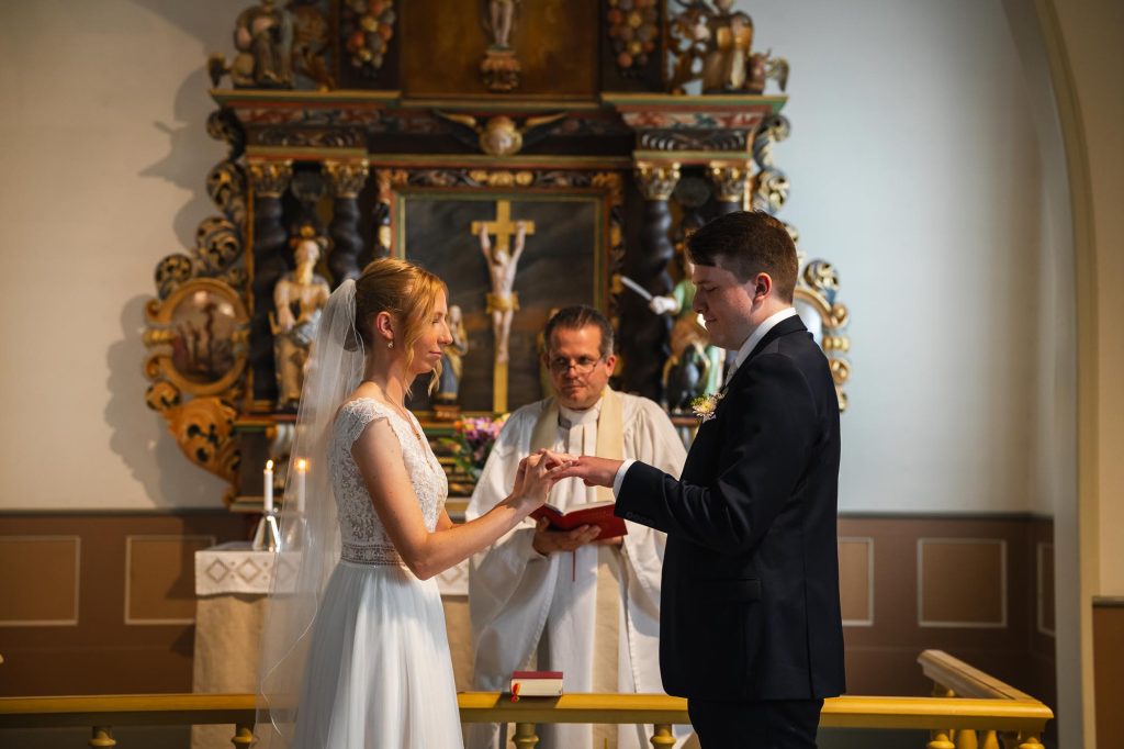 Bruden ger brudgummen vigselringen i Skillingmarks kyrka.