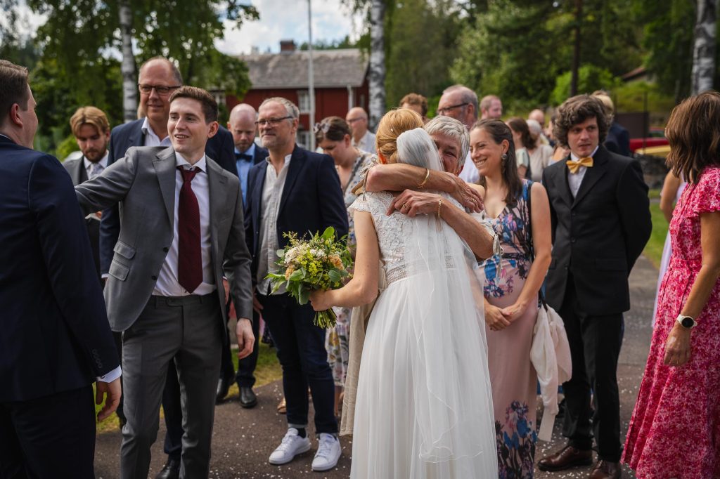 Bruden får en gratulationskram av sin mor utanför Skillingmarks kyrka.