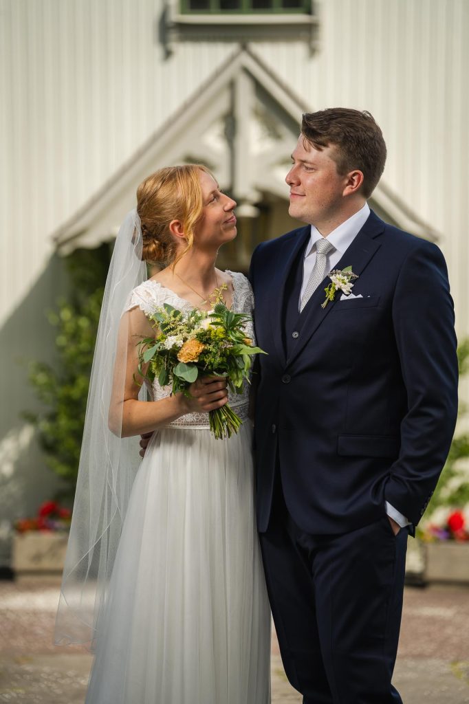 Porträtt av det nygifta brudparet utanför Skillingmarks kyrka.