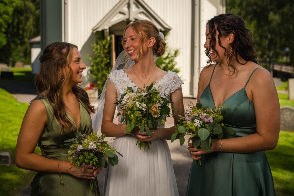 Porträtt av bruden och hennes brudtärnor utanför Skillingmarks kyrka.