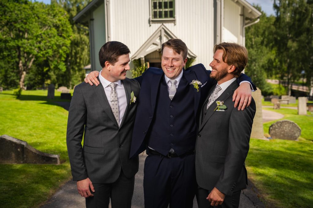 Porträtt av brudgummen och hans best men utanför Skillingmarks kyrka.