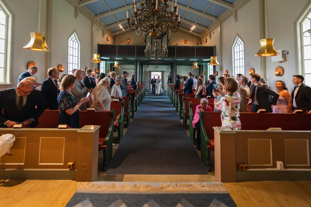 Brudgummen går in i Skillingmarks kyrka med sin far..