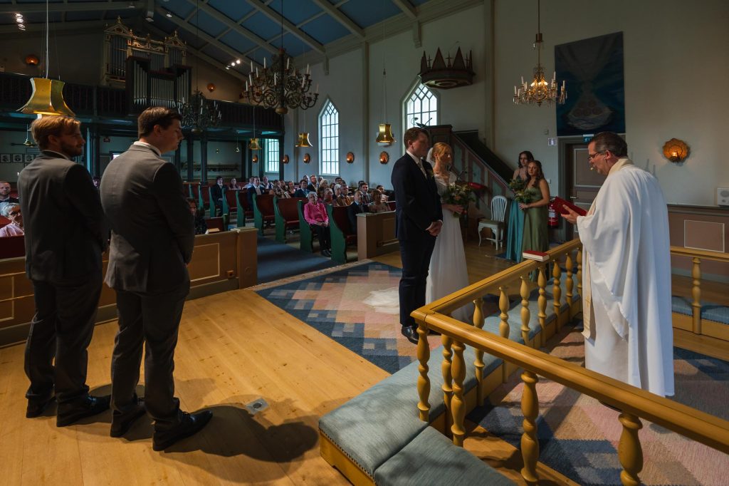 Brudgum och brud står vid altaret för vigsel i Skillingmarks kyrka.