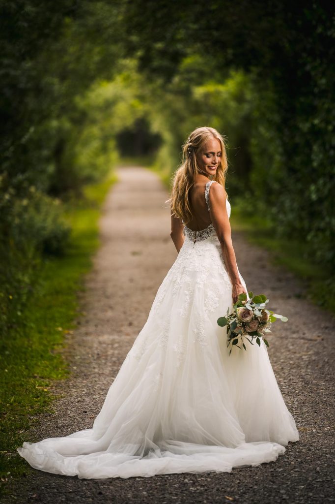 Brud i brudklädsel och med brudbukett på Viksholmen i Arvika.