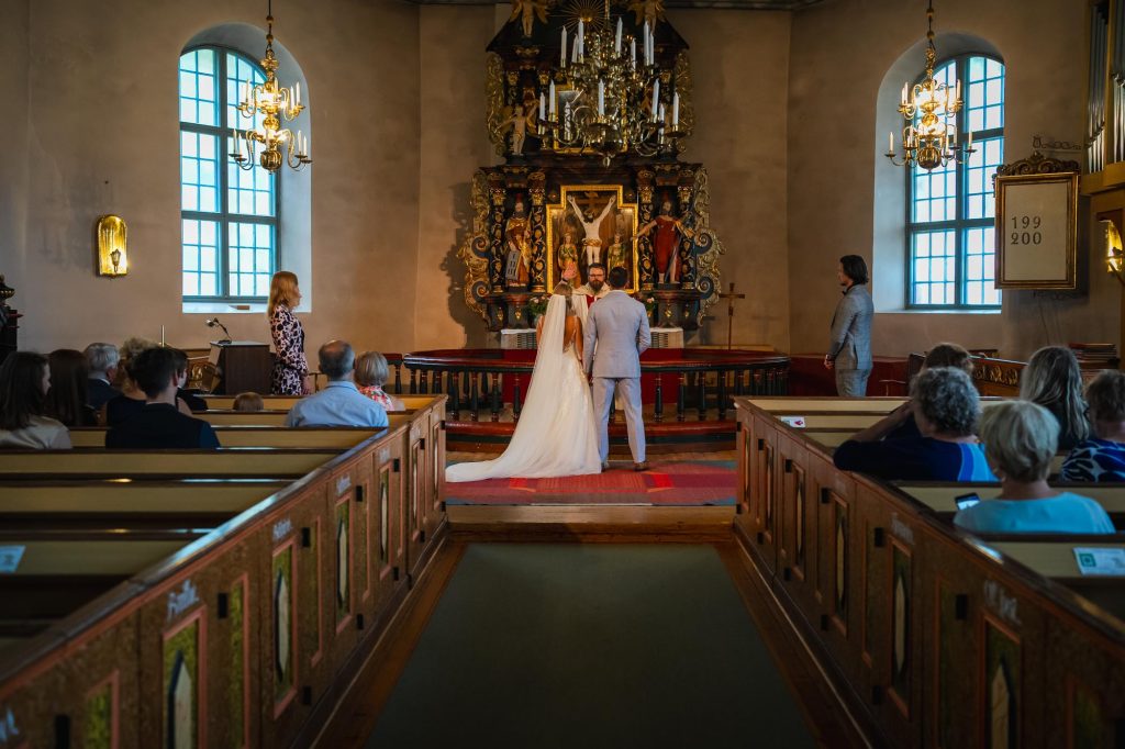 Prästen välsignar brudparet i Mikaelikyrkan i Arvika.