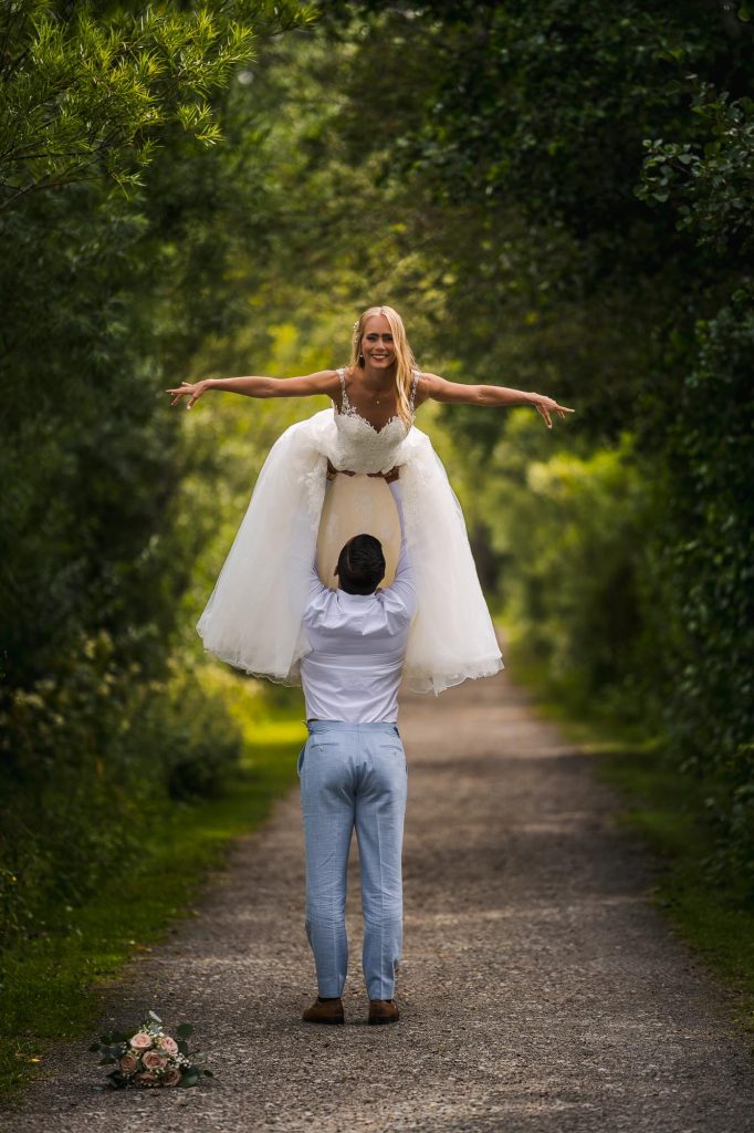 Bröllopsporträtt av brudparet i allén på Viksholmen i Arvika.