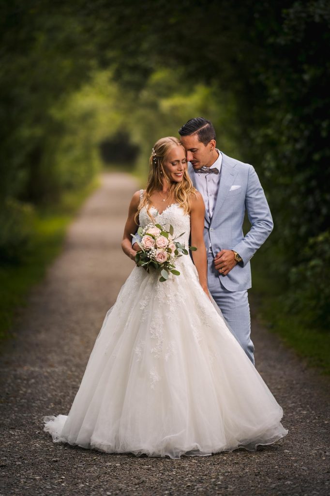Bröllopsporträtt av brudparet i allén på Viksholmen i Arvika.