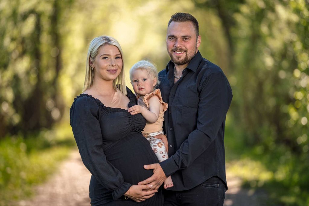 Mor, far och dotter poserar för ett familjeporträtt på Viksholmen i Arvika.