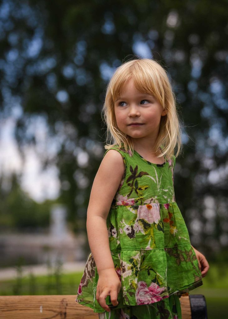 Liten flicka i grön klänning.