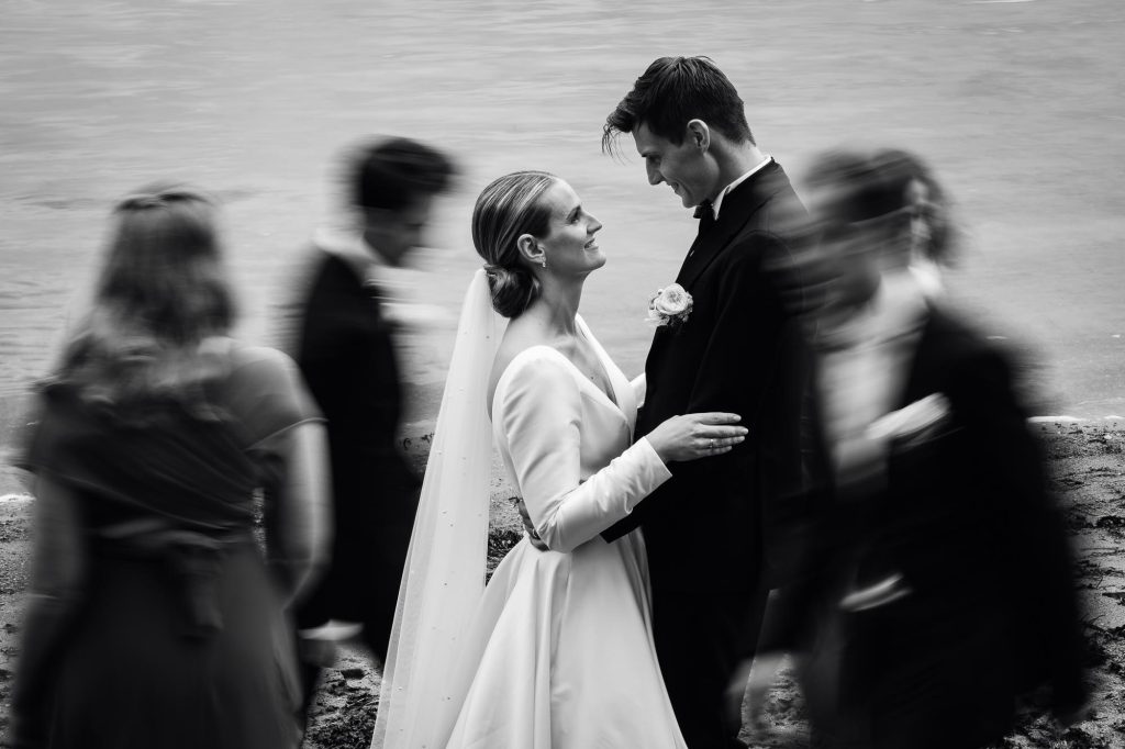 Bruden och brudgummen håller om varandra samtidigt som deras vänner rör sig runt dem.