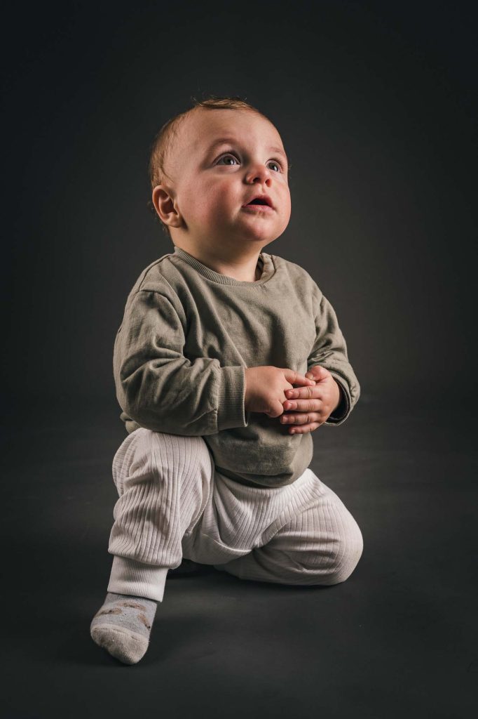 Liten pojke på knä i studio.