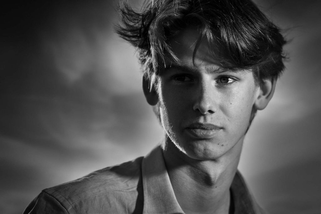 Dramatiskt svartvitt porträtt av ung man.