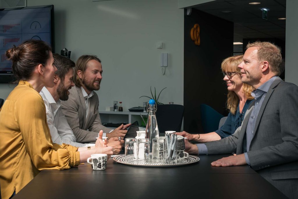 Ledningsgrupp på företag sitter i konferensrum och diskuterar.