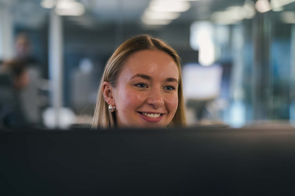 Bild av kvinna bakom datorskärm.