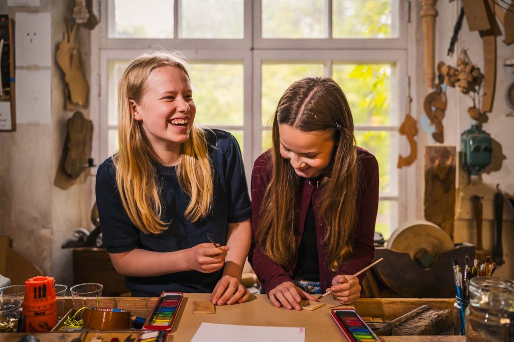 Två små tjejer som har kul på skaparverkstaden på Rackstadmuseet i Arvika.