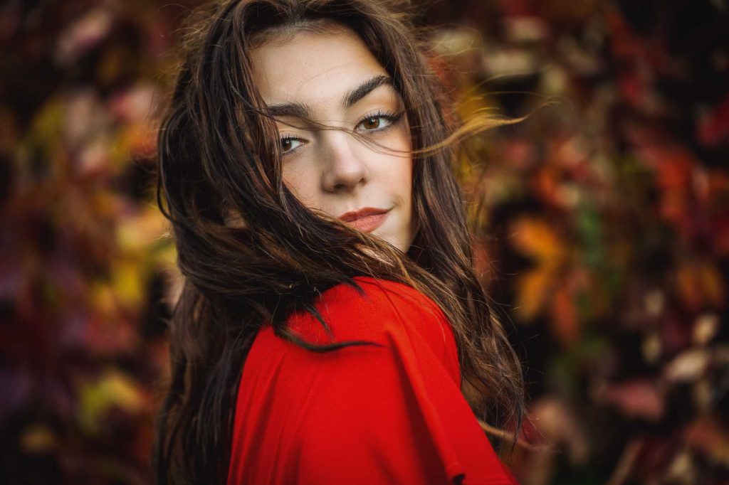 Kvinna i röd klänning, höstbakgrund.