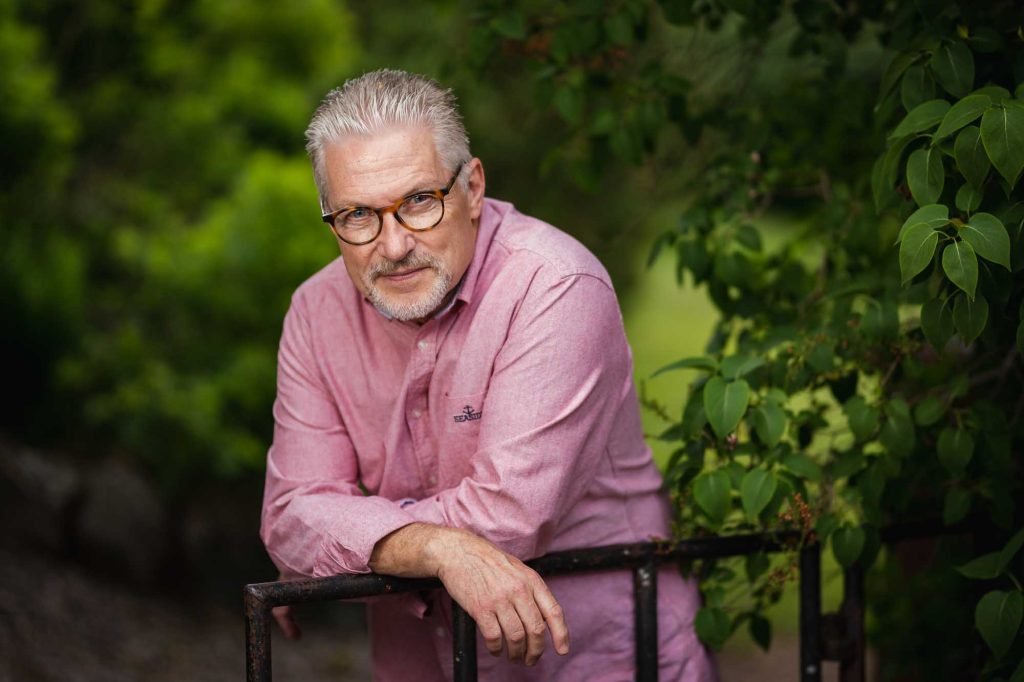 Man i rosa skjorta vid staket