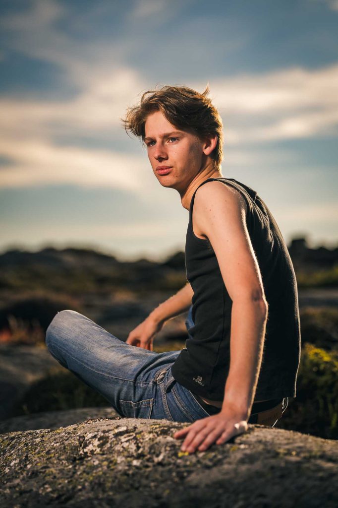 Ung man sitter på klippa.