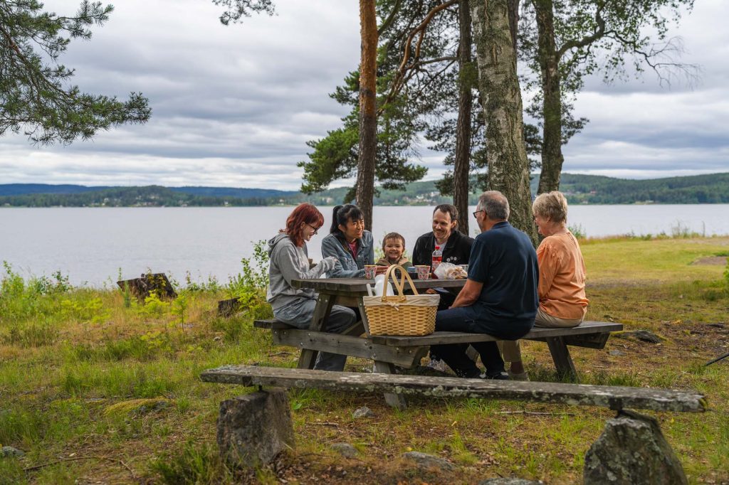 Tre generationer samlas för fika med jordgubbar på Såguddens natursköna område i Arvika.