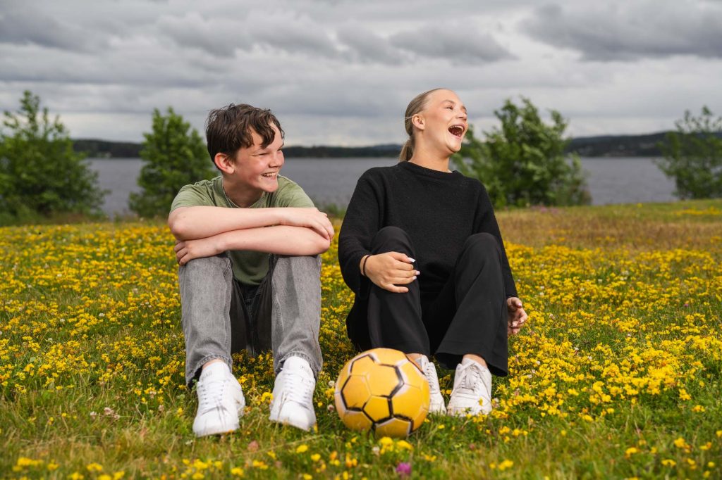 Unga vänner hänger och tar porträtt vid vattnet i Arvikas dynamiska hamnområde.