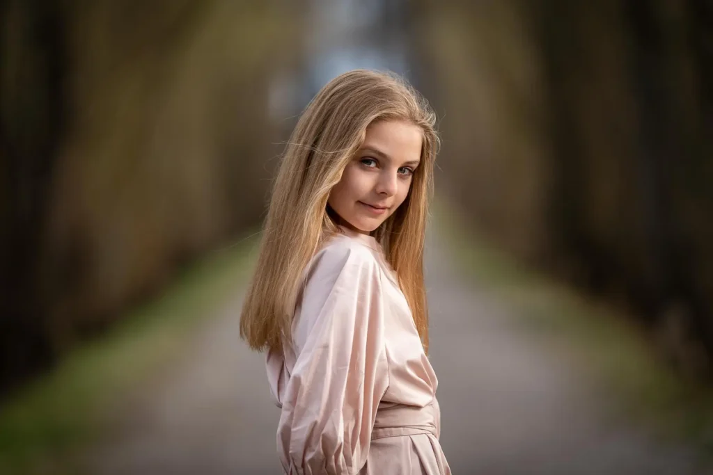 En flicka som ser över axeln under en barnfotografering på Viksholmen i Arvika, fotograferad med mjuk bakgrundsoskärpa.