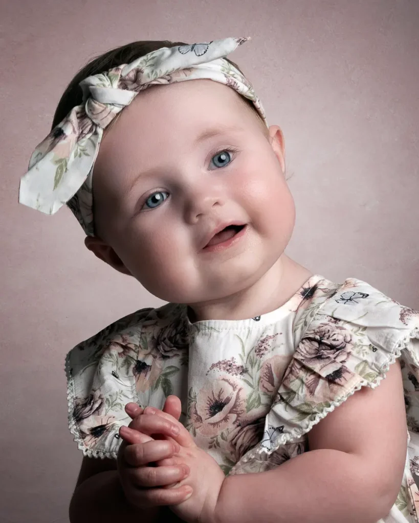 Ett närgånget och charmigt barnporträtt med blommiga kläder och matchande hårband, fotat i Studio PixPep i Arvika.