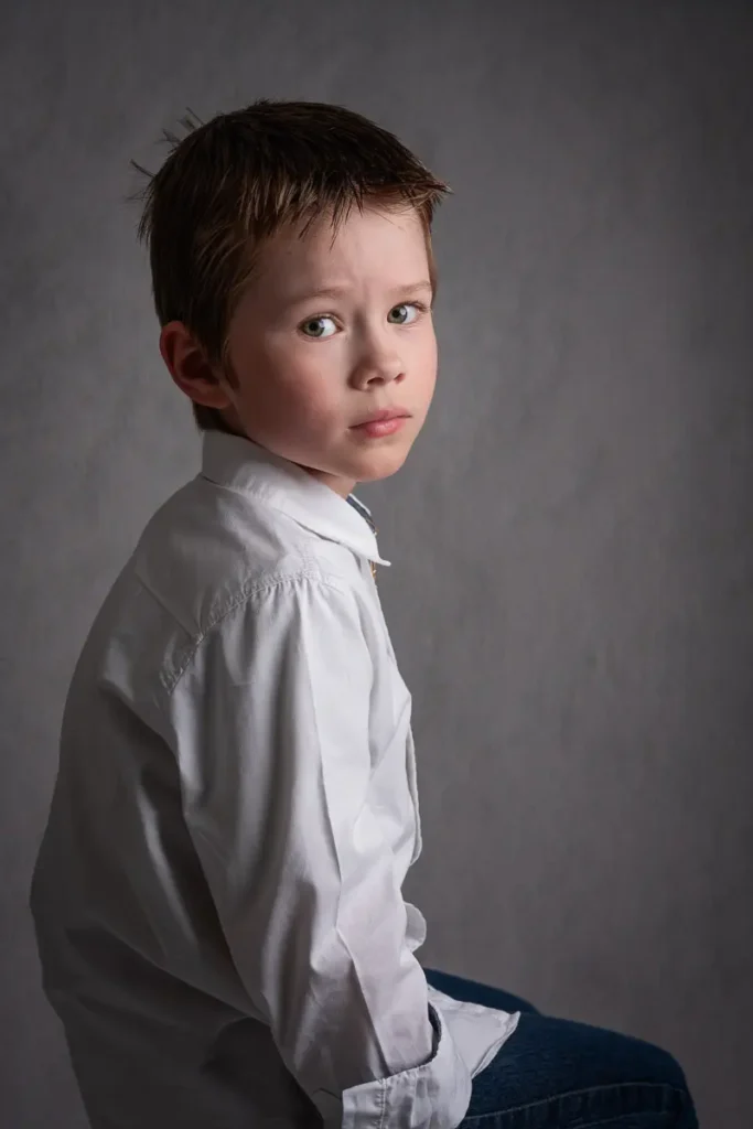 Ett klassiskt och stilrent barnporträtt på en pojke i vit skjorta, fotat hos PixPep i Arvika.