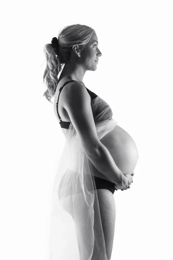 Ett ljust och stilrent svartvitt gravidporträtt i profil, fotat av en gravidfotograf i Studio PixPep i Arvika.
