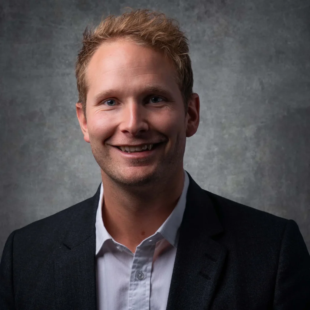 Personalbild tagen med mobilstudio i Värmland, föreställande en blond, leende man i grå kavaj