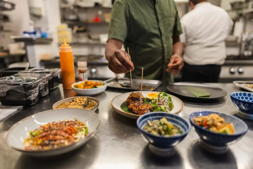 En kock förbereder mat i ett professionellt kök, verksamhetsbild fotograferad av PixPep i Värmland.