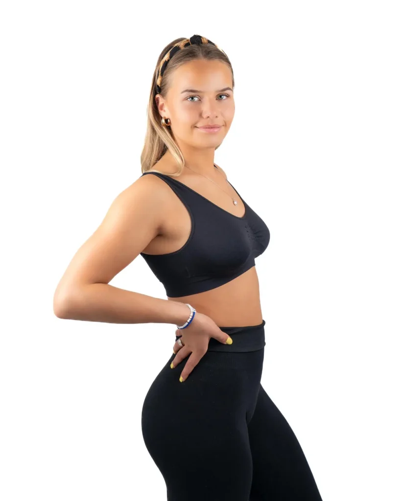 Professionellt studioporträtt av kvinna i svarta träningskläder taget av fotograf i studio i Arvika med vit bakgrund.