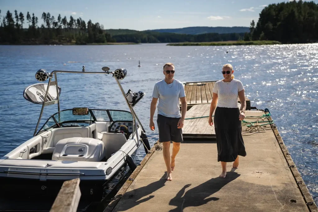 Ett barfota par går på en betongbrygga vid Skagern, Glafsfjorden, efter att ha lagt till med sin motorbåt.