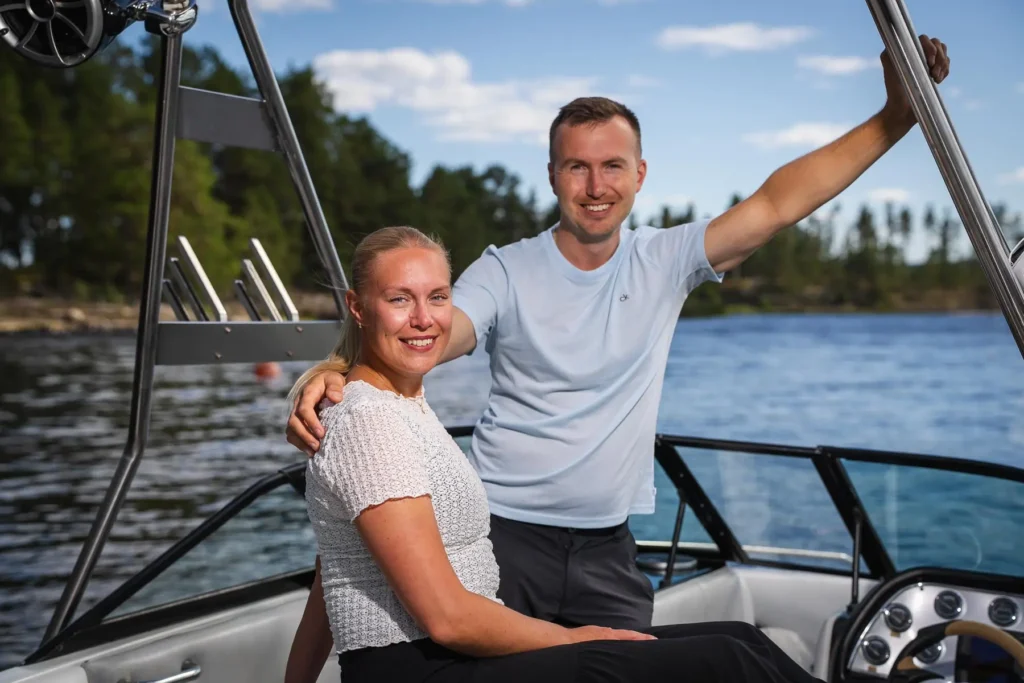 Ett porträtt på ett par i en motorbåt på Glafsfjorden, Arvika, med den värmländska naturen i bakgrunden.