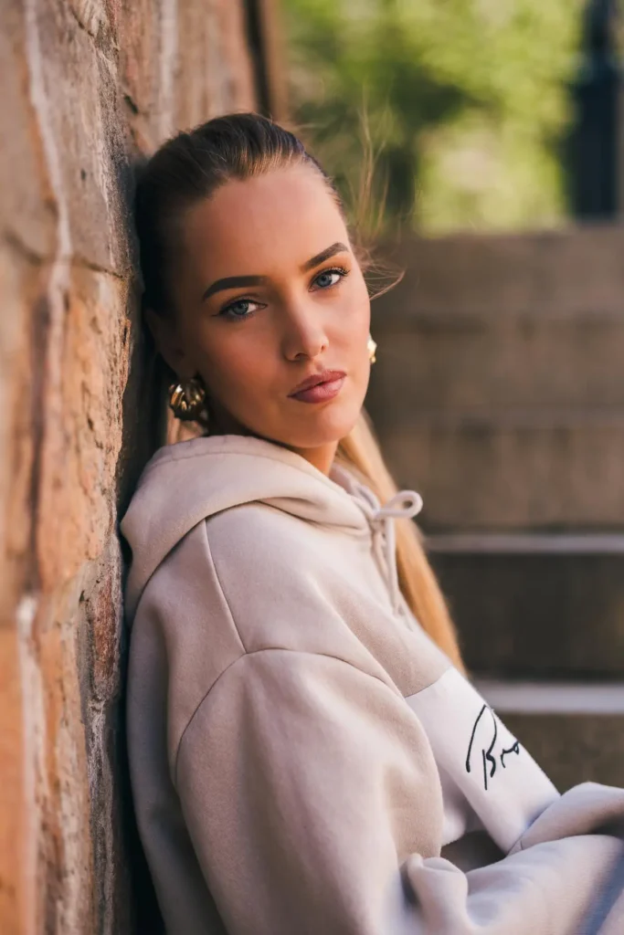 Stämningsfullt porträtt vid stenvägg på Herrhagen i Karlstad, skapat av PixPep – din porträttfotograf i Värmland.